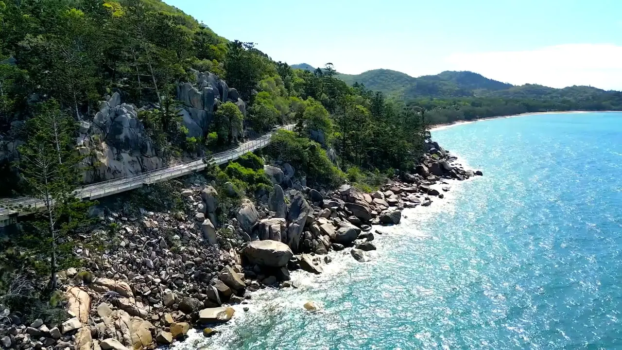 Aerial view of the Magnetic Island coastline with granite boulders, a boardwalk and turquoise water